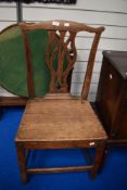 An 18th century vernacular primitive form chair with oak frame and carved vase style back.