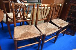 A set of three 19th Century stained frame spindle back kitchen chairs having rush seats , of