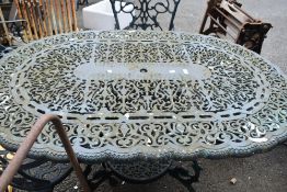A modern cast metal garden table and chair set.