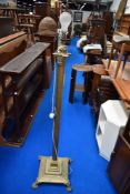 A Victorian standard lamp in brass with lions feet and classical column.