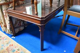 An early 20th century coffee table with glazed top and mahogany frame.