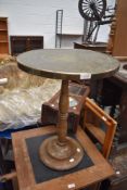 An Anglo Indian style circular brass table top on turned wooden column base (possibly marriage)