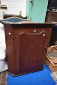 An early 20th century pine corner cupboard with a scumble paint finish.