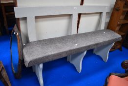 A painted wood bench having rail back and later upholstered seat, width approx. 142cm