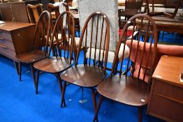 A set of four Dark stained Ercol hoop back dining chairs.