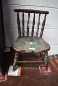 An antique apprentice style miniature chair with bobbin back and shaped seat.