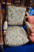 A Victorian Arts and Crafts arm chair having carved frame work with upholstery.