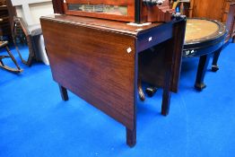 An Edwardian drop leaf mahogany dining table.