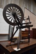 An antique primitive form spinning wheel having turned frame.
