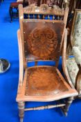 A Victorian rocking chair with embossed seat and back.
