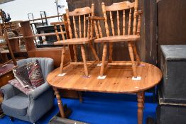 A modern pine dining table with two chairs.
