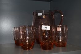 A vintage peach coloured glass and controlled bubble lemonade set, comprising jug and four tumblers,