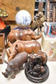 A print decorated ostrich egg, and four carved wooden African animals and a cast-resin elephant