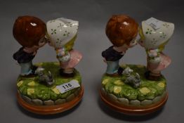 A pair of mid-century pottery figurines in the manner of Hummel, two kissing children with