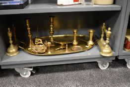 A selection of brass wares including a pair of fire dogs, candle sticks and a large brass tray.
