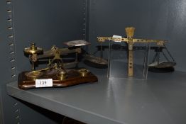 A set of vintage postal scales with a similar partial set and some brass weights.