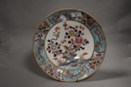 A Chinese enamelled porcelain plate, decorated with flora and fauna within a diaper and foliate