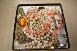 A selection of vintage costume jewellery including simulated pearls, brooches and a monocle.