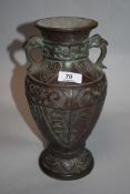 A Chinese cast-metal vase, of traditional baluster form with two bird head handles archaic