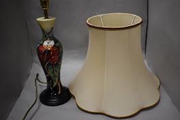 A Moorcroft pottery baluster table tamp, tube-lined in the Simeon pattern against a washed blue to