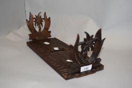 A vintage softwood slide fold out book shelf wooden carved with decorated ends.