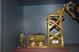 An interesting mahogany mounted brass mining diorama depicting a miner, coal filled carriage and