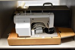 A New Home electric sewing machine with case and accessories.