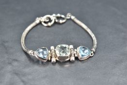 A blue topaz and aqua marine trio stone bracelet in white metal collared mounts on snake link