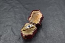 An Art Deco sapphire and diamond trilogy ring having central sapphire approx 0.25ct flanked by two