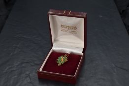 A fourteen stone marquise cut emerald pendant having two small central diamonds in a yellow metal
