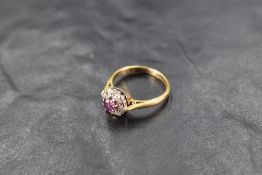 A ruby & diamond chip cluster ring having an illusionary setting and 18ct gold loop, size I & approx