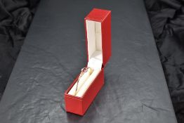 A 9ct gold hinged bangle having a small ruby and diamond set panel to front, approx 6.5g