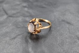 A citrine ring having an oval stone in a frilled claw set mount on a 9ct gold loop, size O/P &