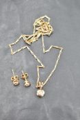 A small diamond solitaire pendant, approx 0.05ct in a yellow metal collared mount on a 9ct gold