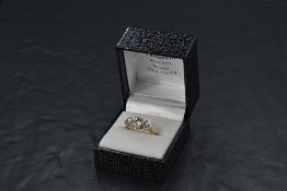 A diamond trilogy ring, having a central 1ct brilliant cut diamond flanked by two 0.5ct brilliant