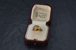 A facet cut citrine ring of octagonal form having a four claw basket mount to diamond chip set