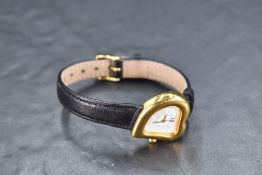 An Yves Saint Laurent ladies quartz wrist watch with gold plated heart shaped case and black leather