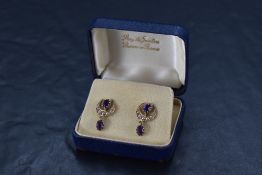 A pair of 9ct gold antique style amethyst and seed pearl stud earrings having seed pearl set