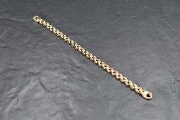 A yellow metal articulated bracelet having brick effect links, no marks but presumed gold, approx