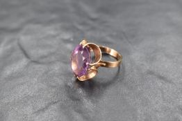 An oval amethyst ring having a claw set stylised mount on a 9ct gold loop, size M & approx 4.7g