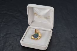 A black opal doublet pendant with diamond decoration in a stylised twist yellow metal mount