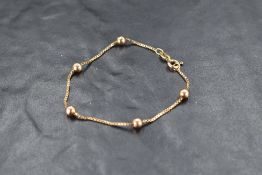 A 9ct gold box link chain bracelet having spherical decoration, approx 3g