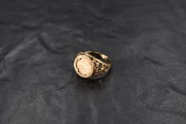 A 9ct gold coin ring containing a small yellow metal copy coin depicting St George to one side and