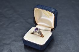 An amethyst and diamond chip cluster ring having bark effect yellow metal loop stamped 18ct, size