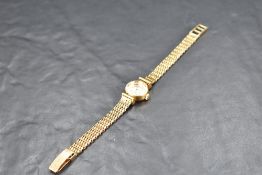 A lady's 18ct gold Omega wrist watch having baton numeral dial to small champagne face in gold