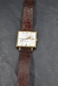 A gent's 9ct gold wrist watch by Rotary having a baton numeral dial to square champagne face in