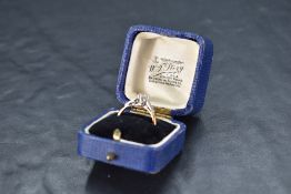 A diamond solitaire ring, approx 0.25ct in a raised claw set mount having diamond chip set shoulders
