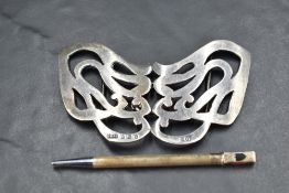 A silver nurses buckle of moulded scroll form and a retracting silver bridge pencil