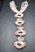A 1980's oversized statement necklace by Butler & Wilson having seven pink agate panels in a white