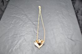 A yellow metal heart pendant stamped 14K on a 9ct gold belcher chain, gross weight 4.5g
